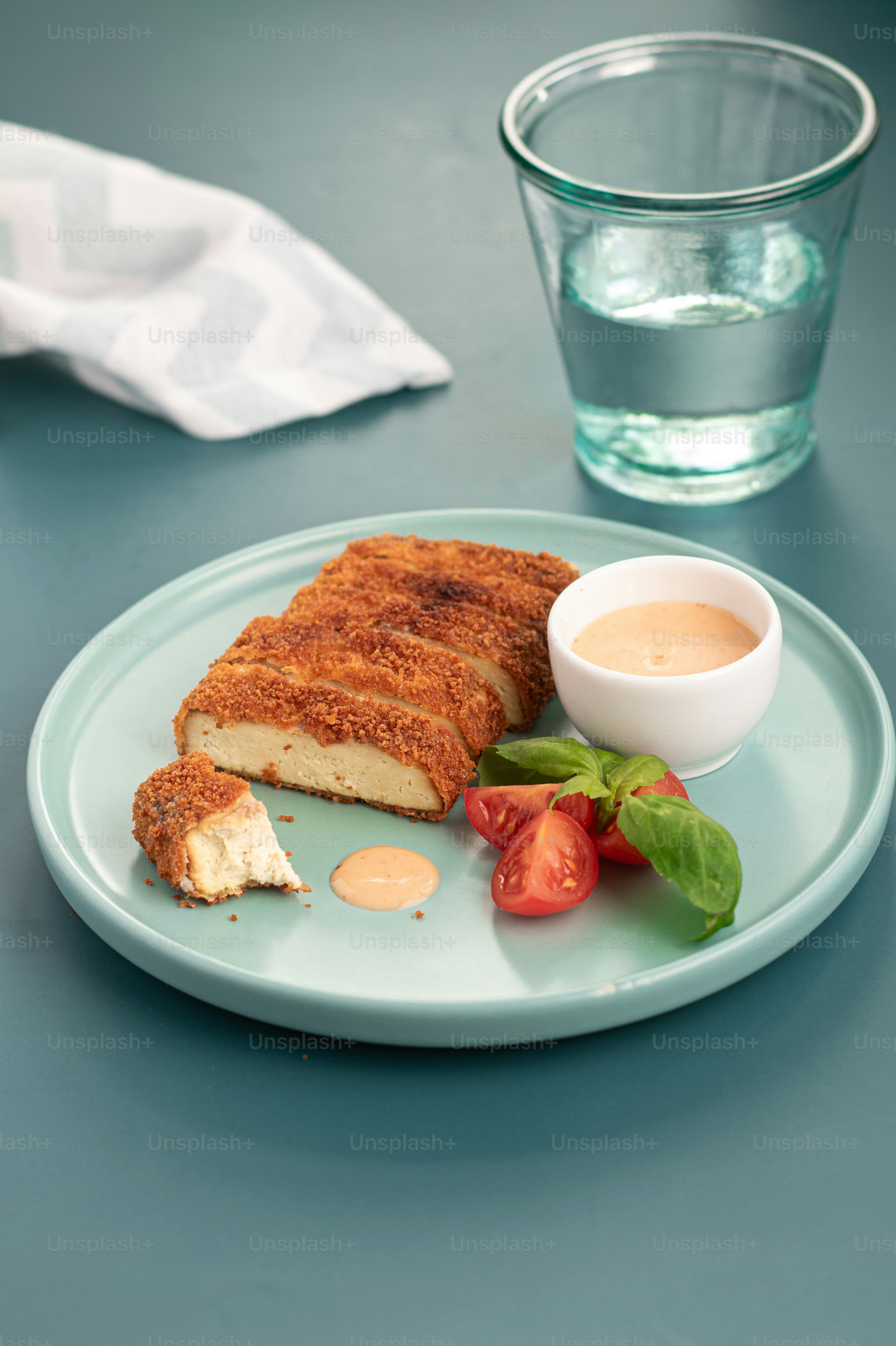 a plate with a piece of bread and a small bowl of dipping sauce