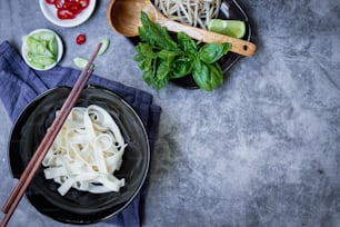 a bowl of noodles and chopsticks on a table