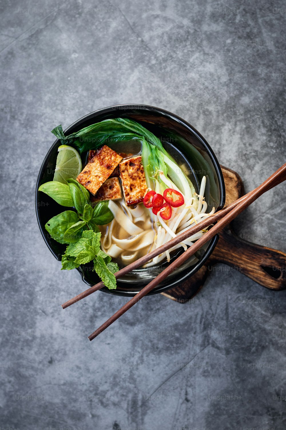 a bowl filled with noodles, meat and vegetables