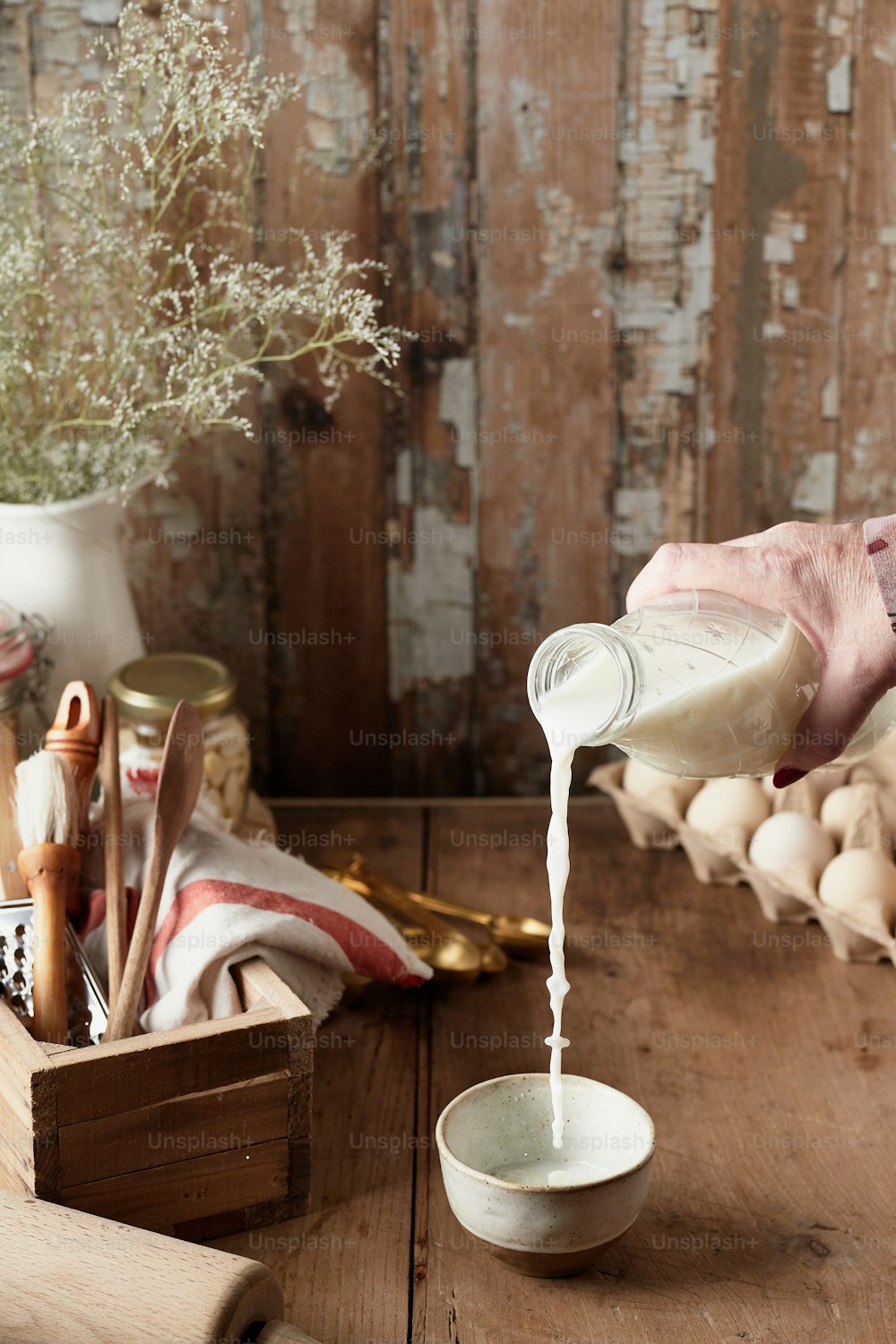 a person pouring milk into a small bowl