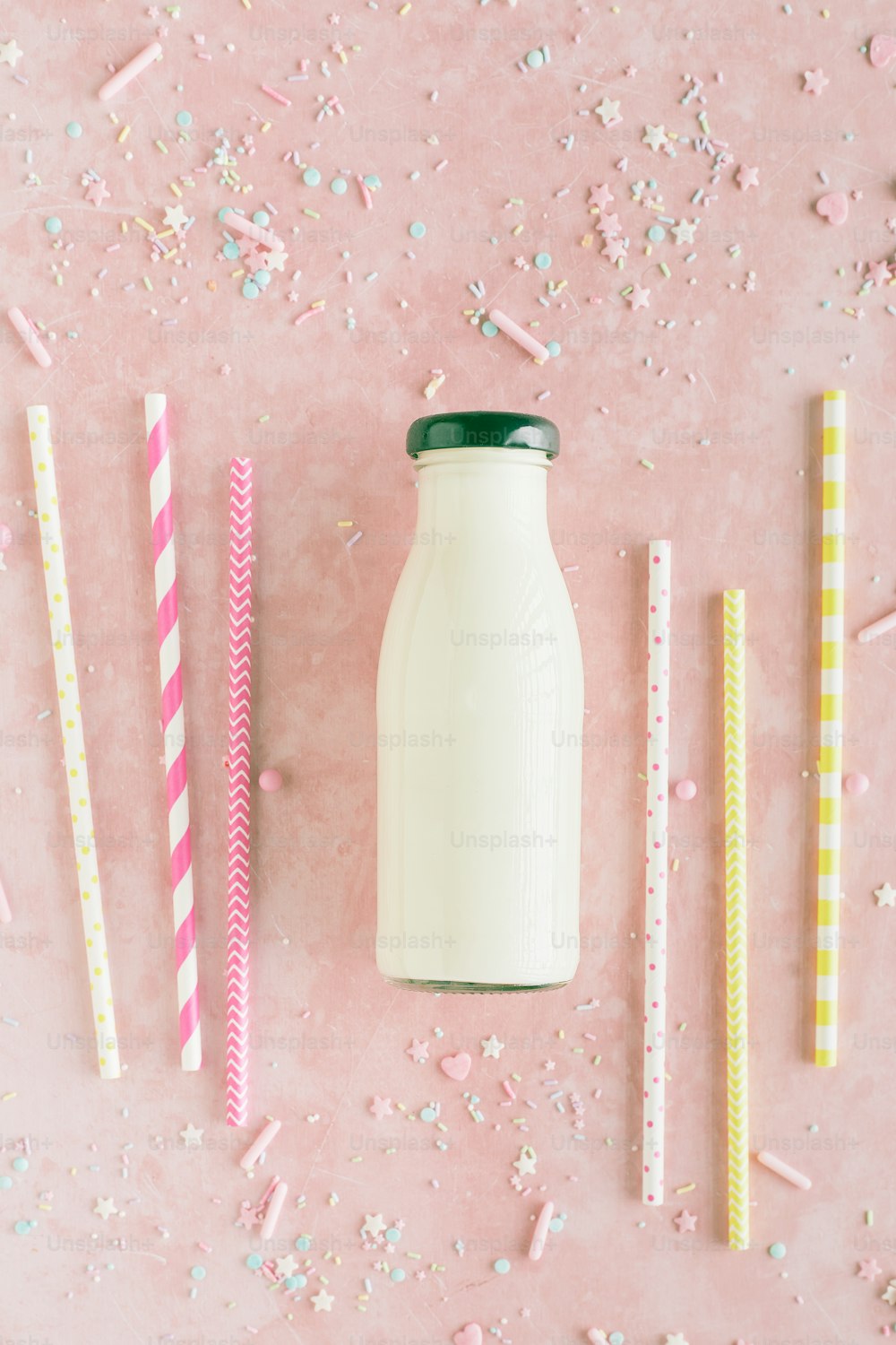 a bottle of milk surrounded by straws and paper straws