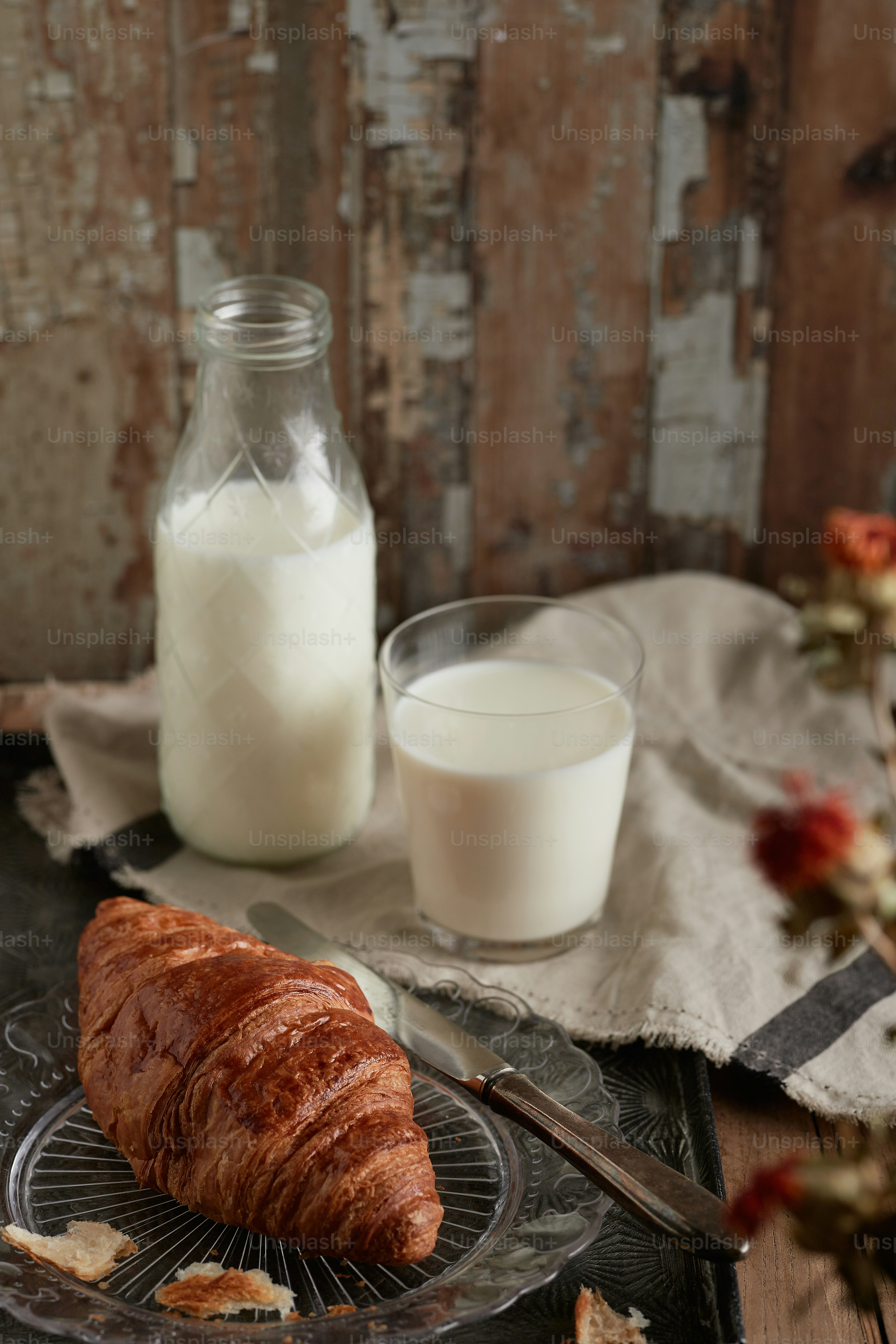 un vaso de leche y un croissant sobre una mesa