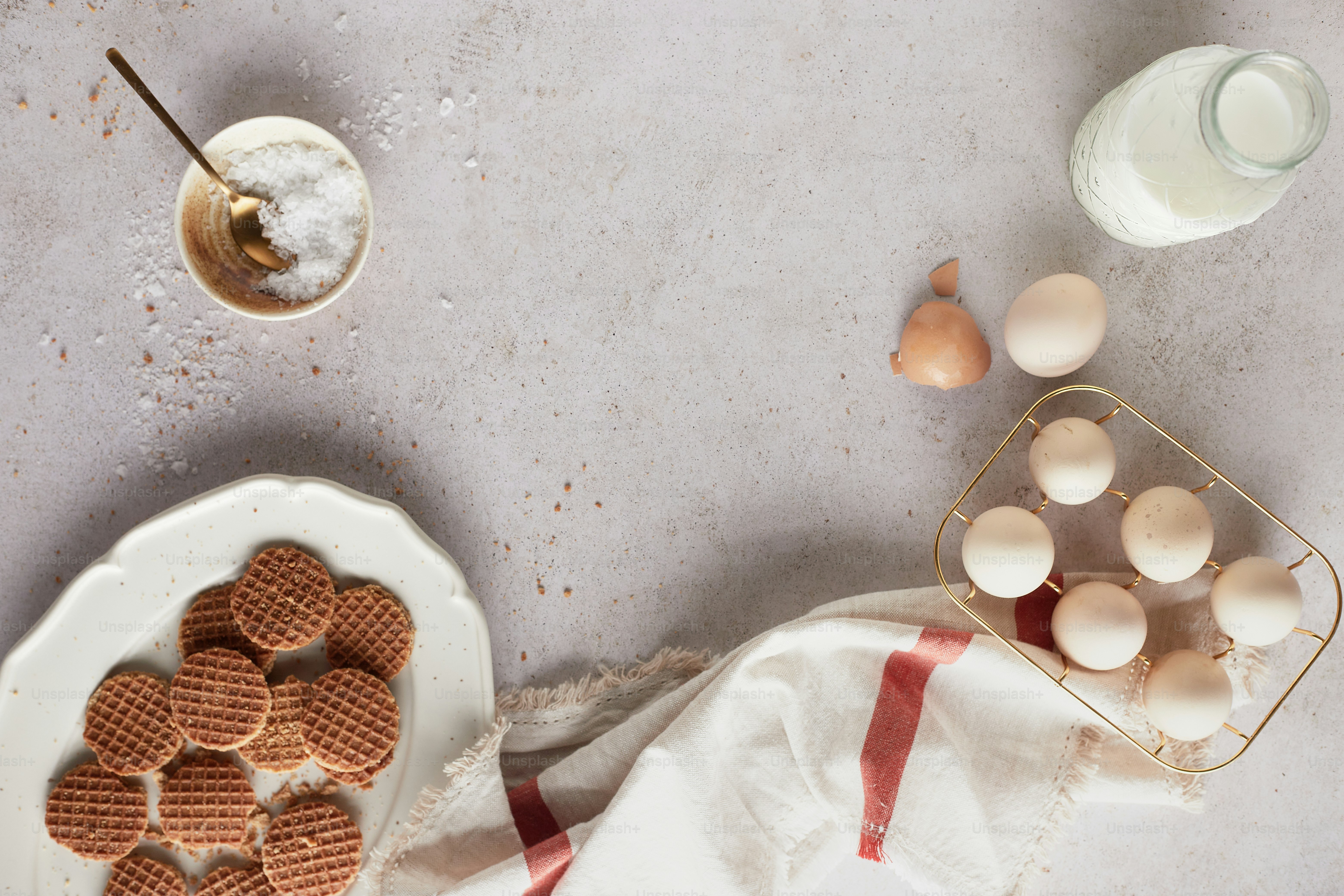 a plate of waffles next to a bowl of eggs