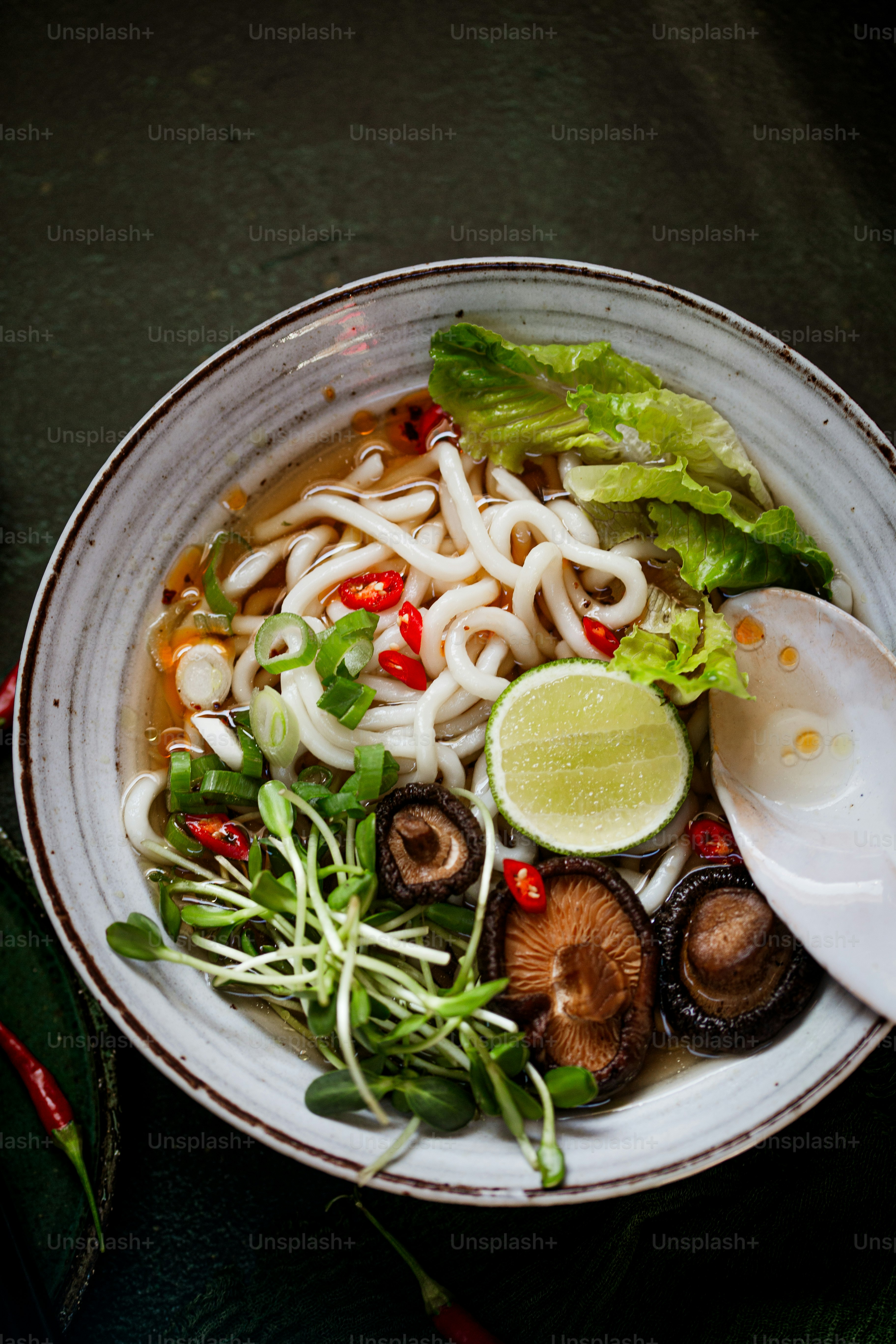 un tazón blanco lleno de fideos y verduras