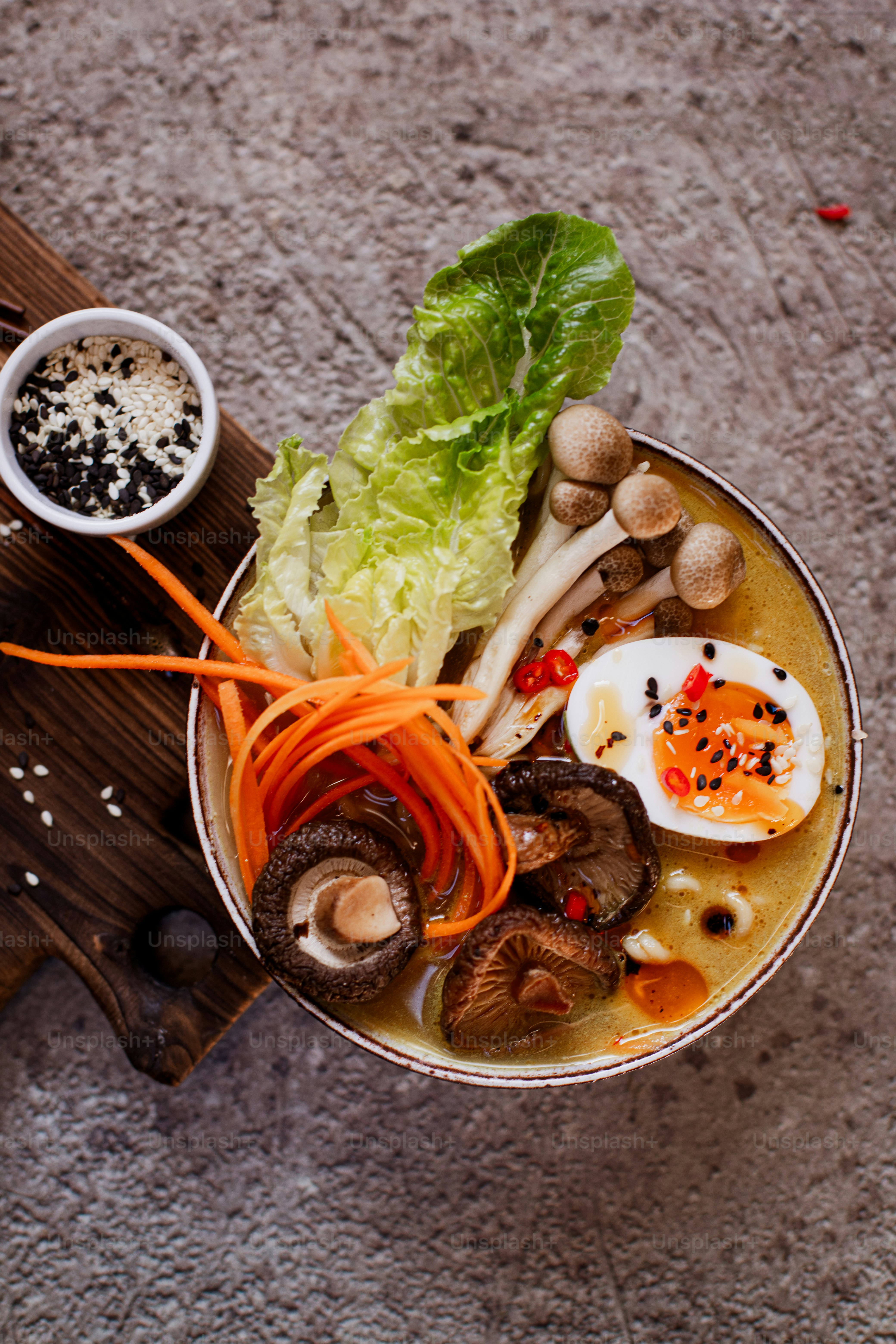 un plato de sopa con champiñones, zanahorias, lechuga y un huevo