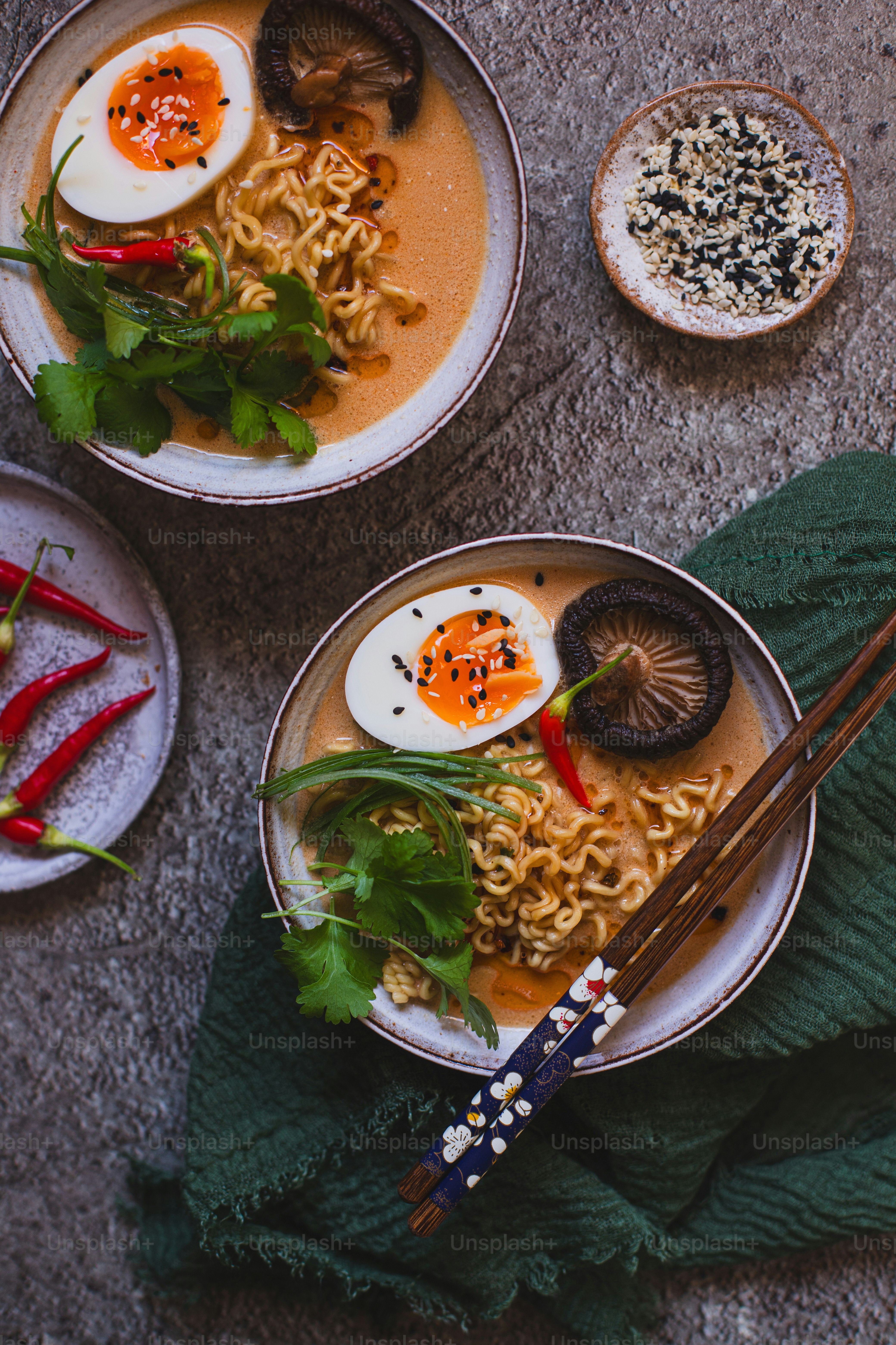 two bowls of ramen with chopsticks on a table