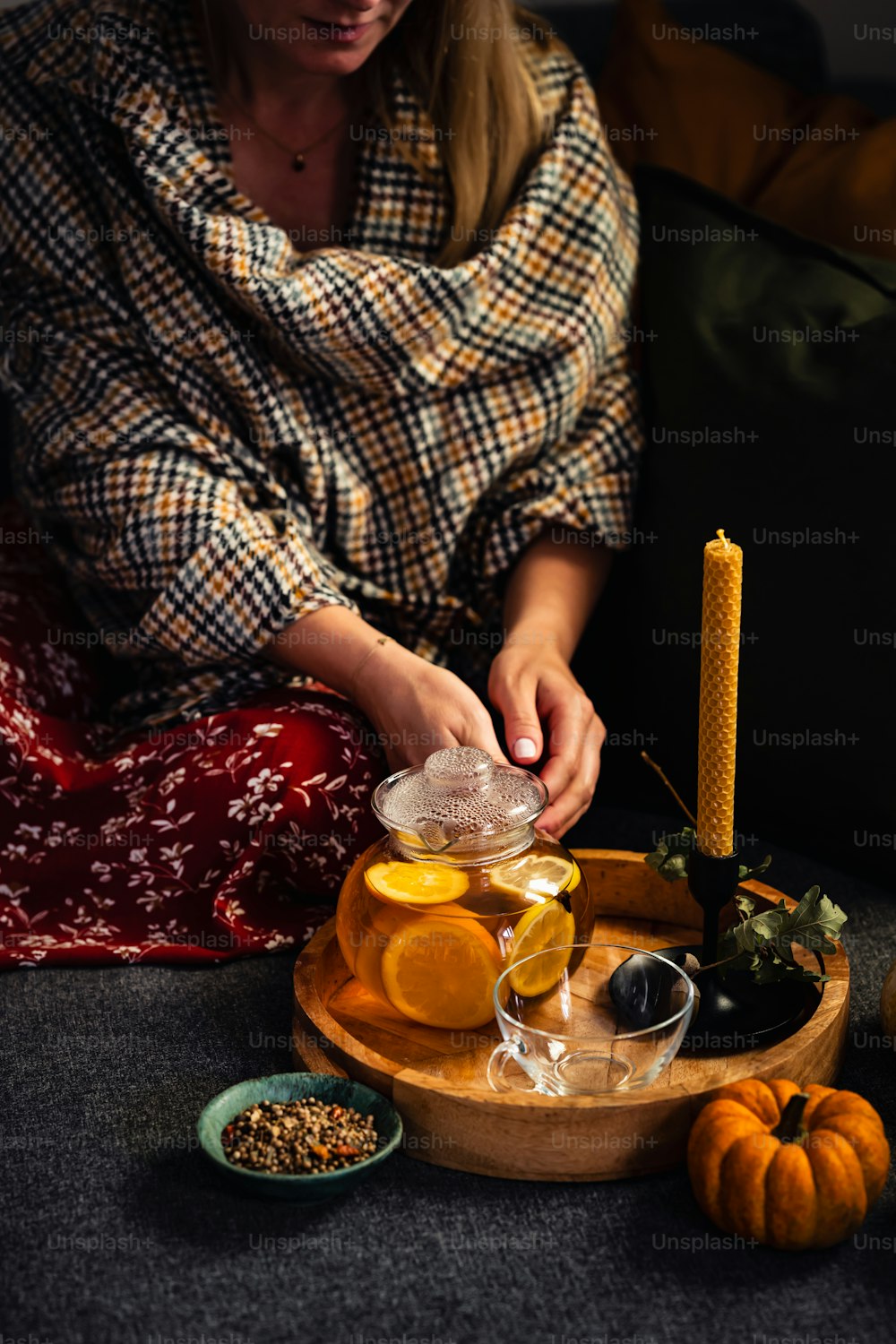 uma mulher sentada em um sofá ao lado de uma bandeja de comida