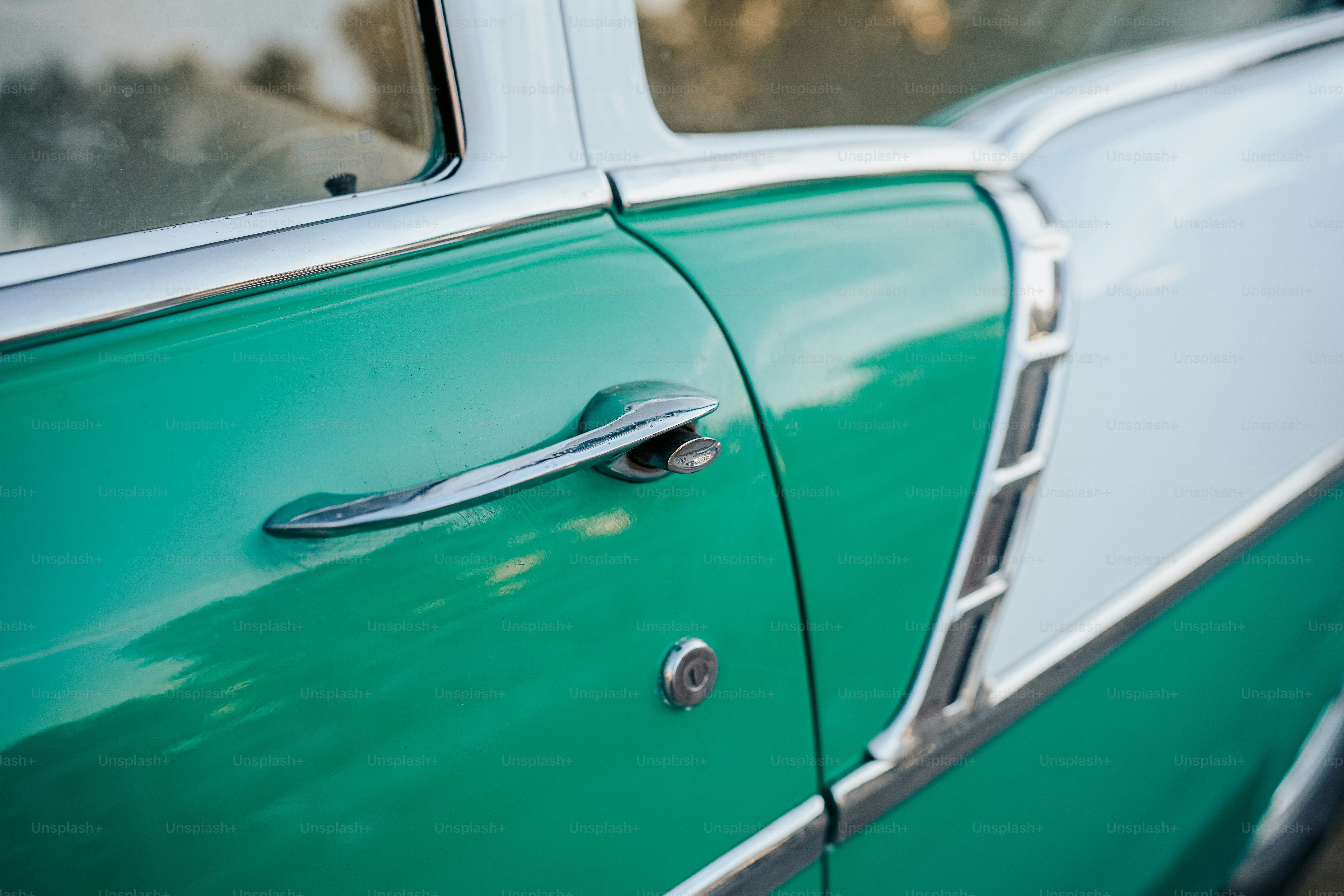 a close up of a door handle on a green car