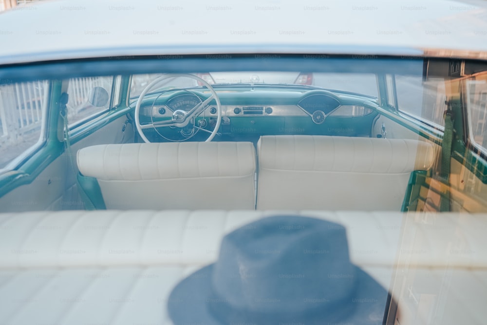 the interior of a car with a hat on the dashboard