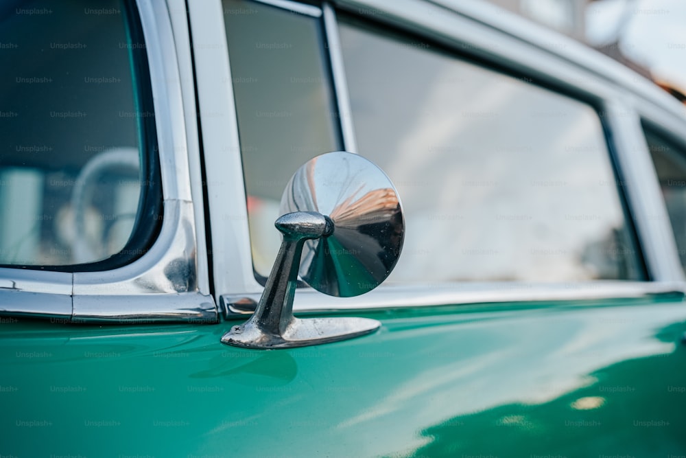 a close up of the side mirror of a green car