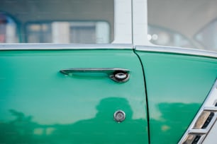 Un primer plano de la manija de una puerta en un coche verde