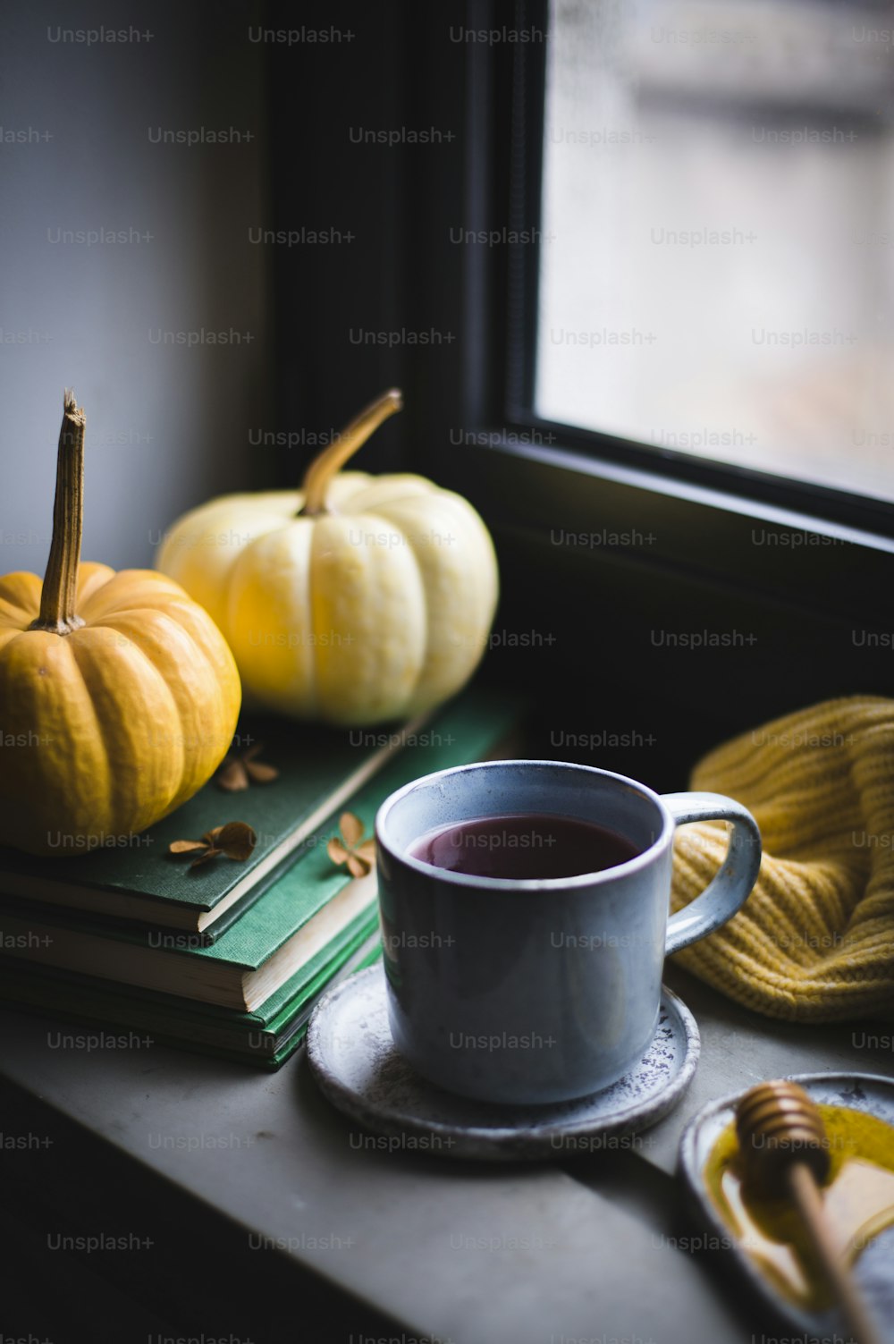 Una taza de café encima de una mesa junto a una ventana