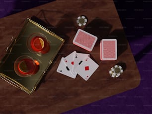 a wooden table topped with playing cards and candles