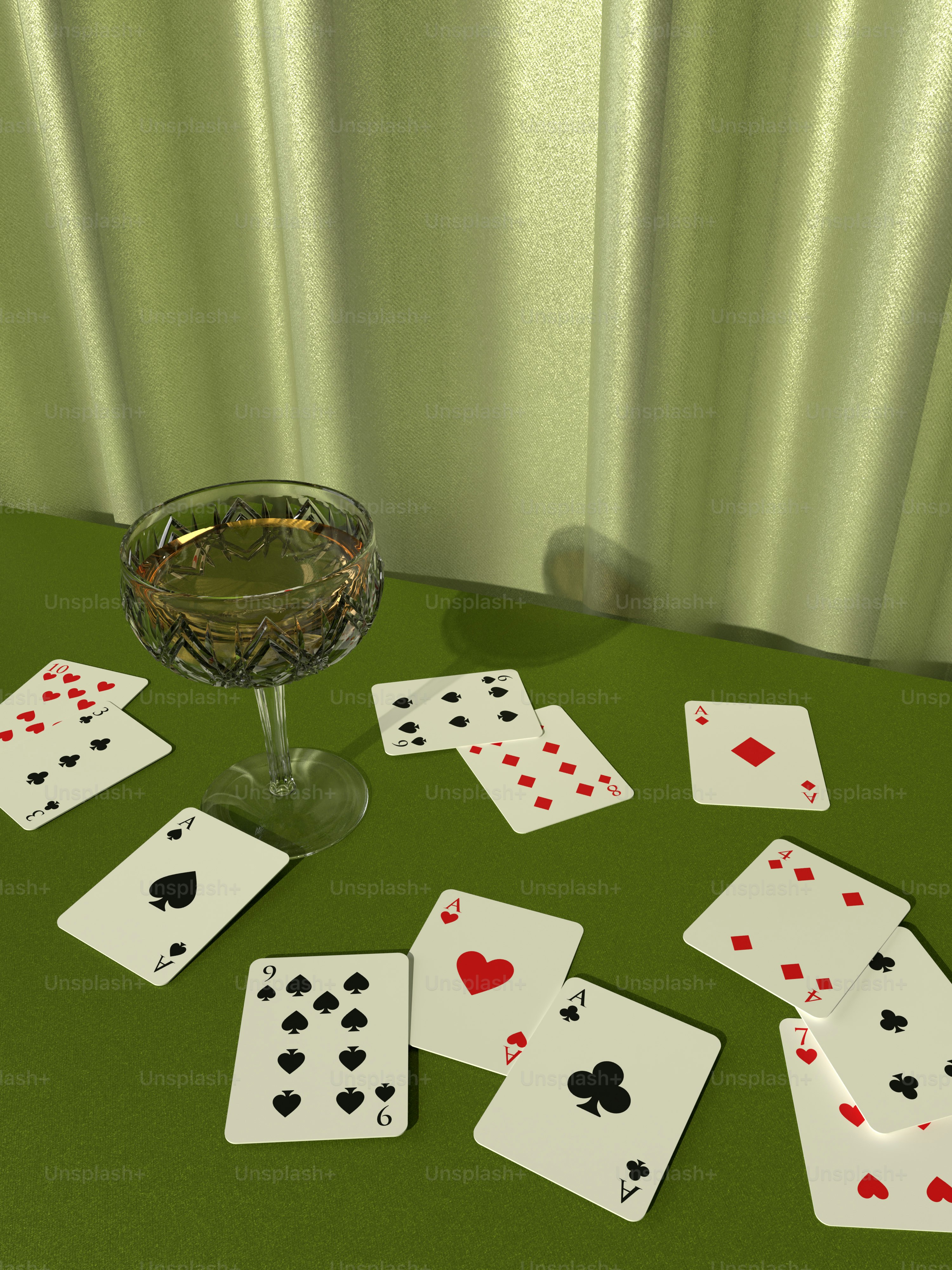 a glass of wine and playing cards on a table