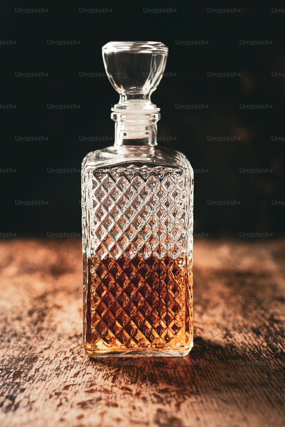 a glass bottle of whiskey on a wooden table