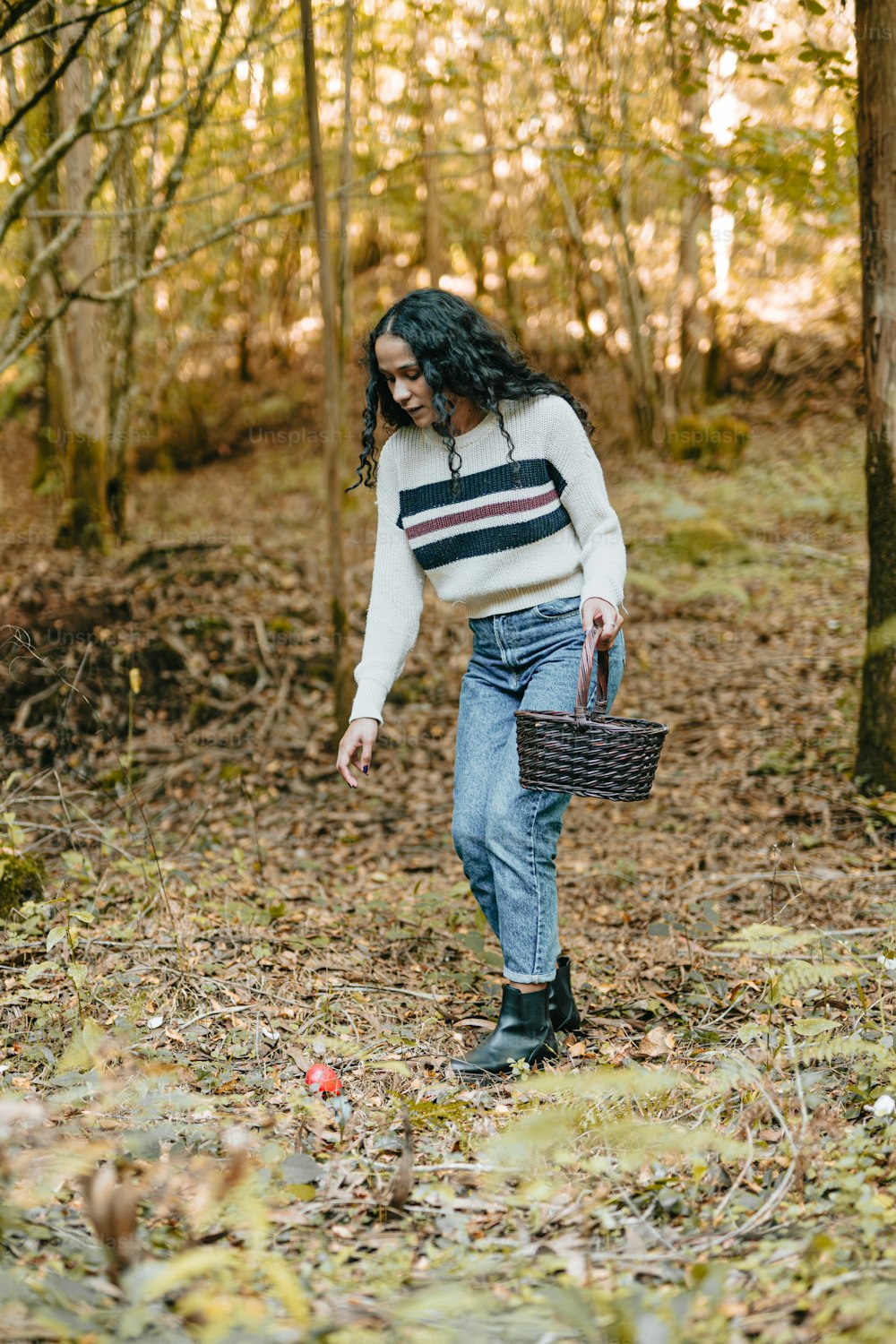 a woman walking through a forest carrying a basket