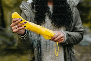 Una mujer sosteniendo un plátano en la mano