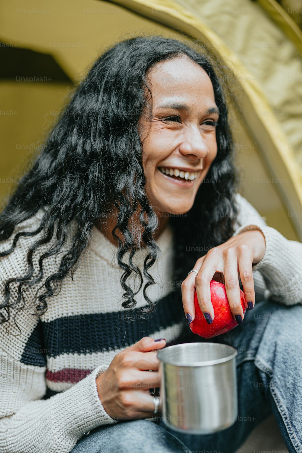 a woman sitting on the ground holding a cup