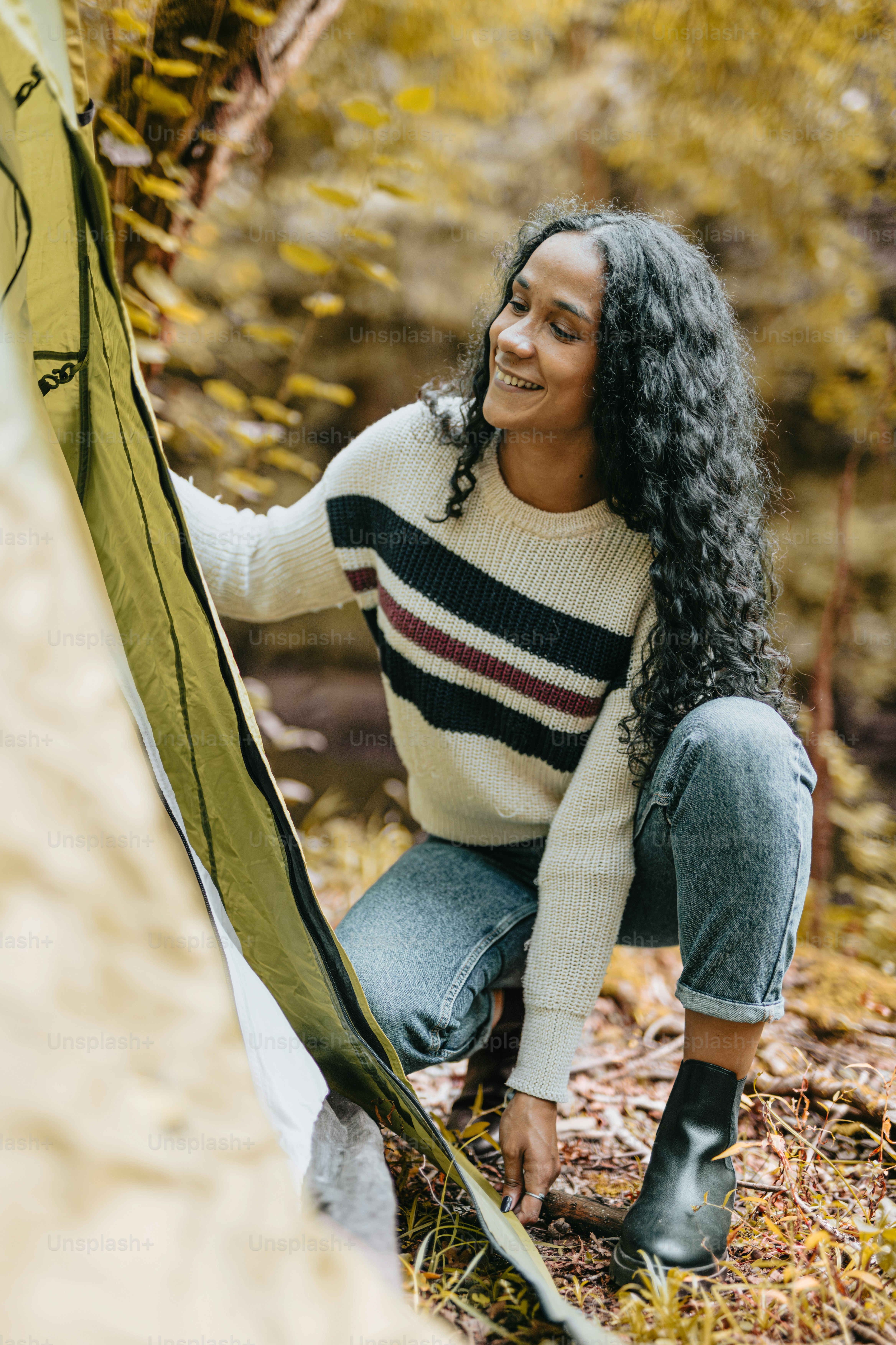 Seorang wanita sedang mendirikan tenda di hutan