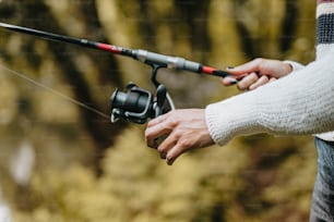 a person holding a fishing rod and a fishing pole