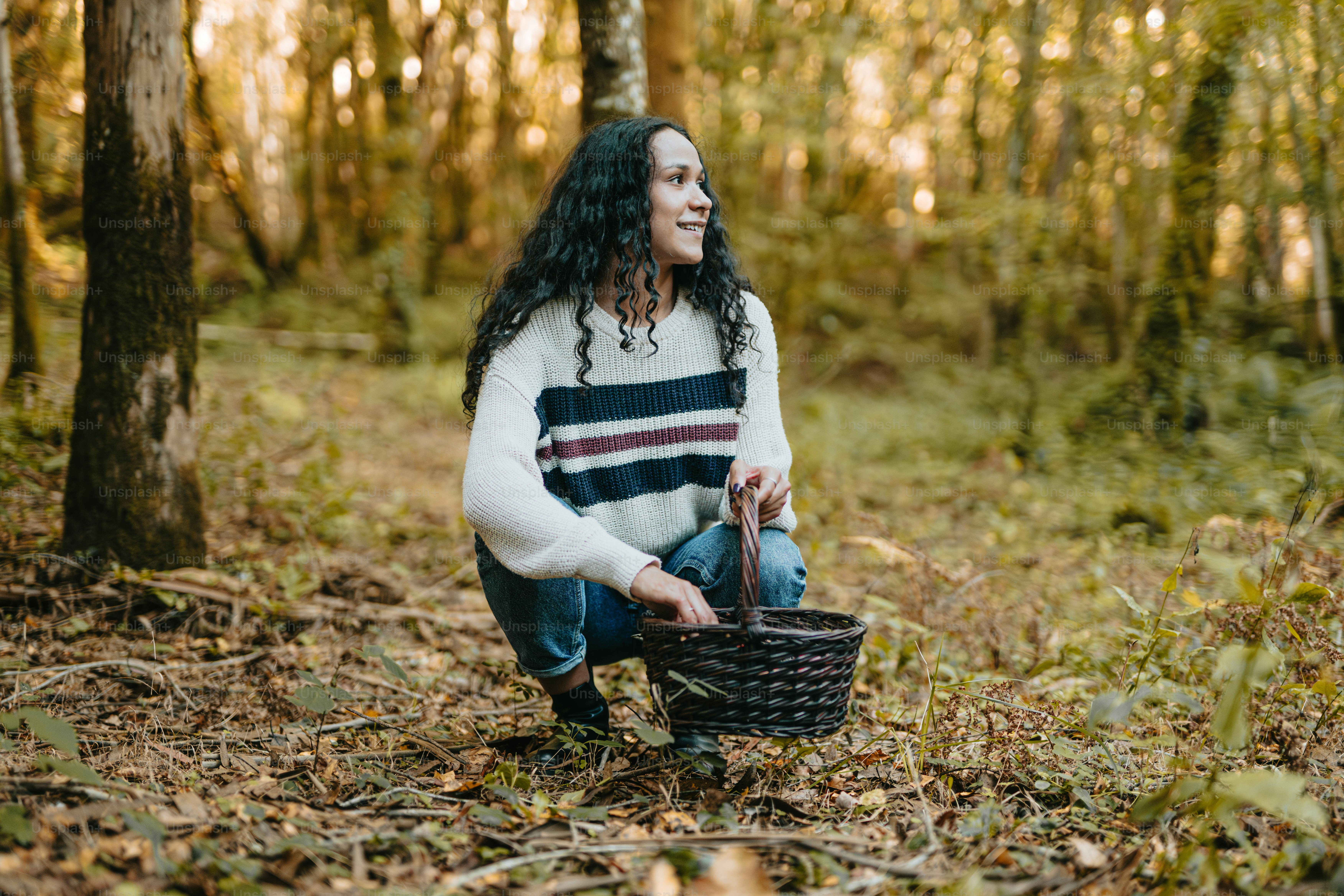 Eine Frau, die im Wald kniet und einen Korb hält