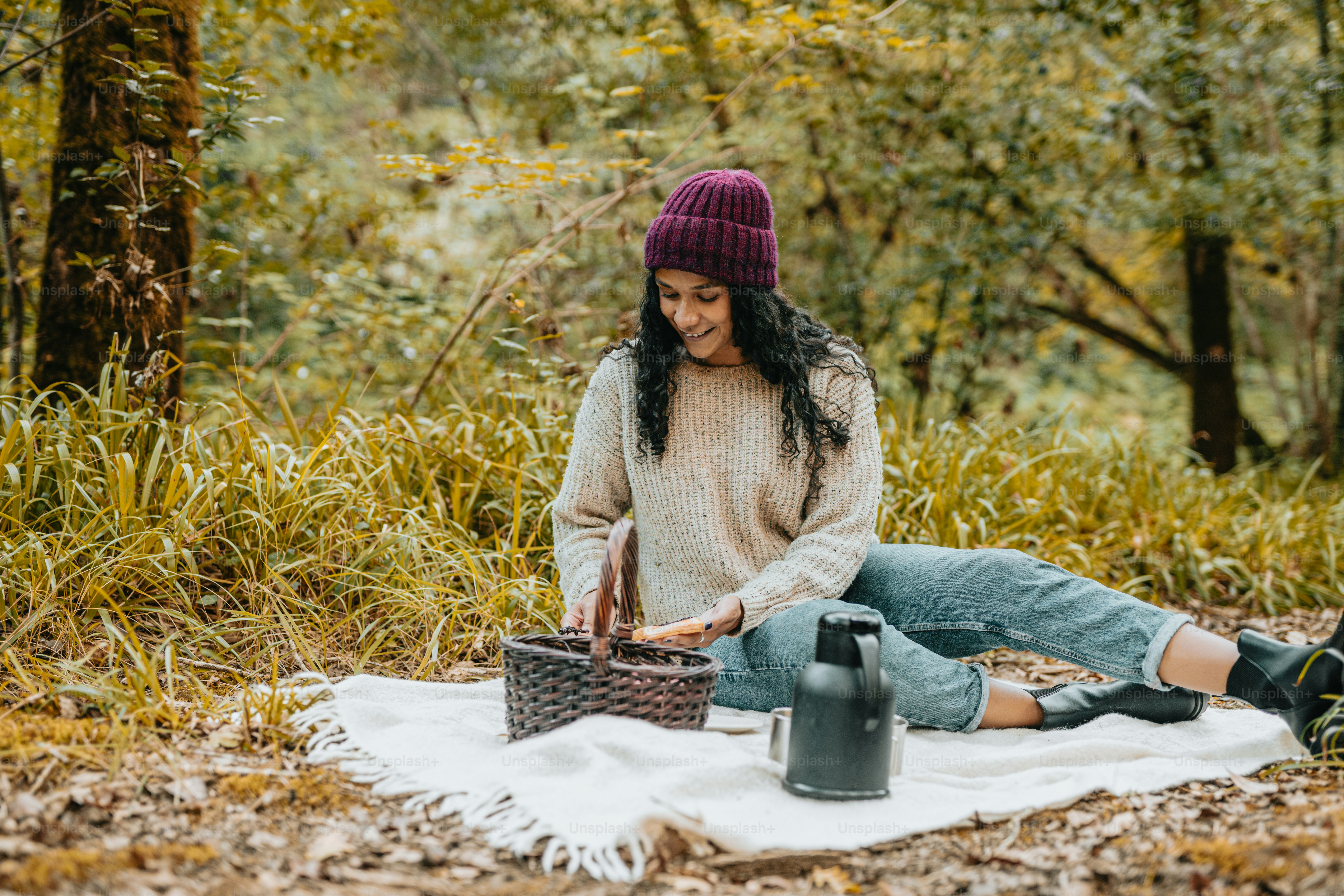 eine frau, die auf einer decke im wald sitzt