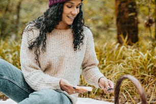 a woman sitting on the ground holding a remote control