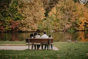 a group of people sitting on top of a wooden bench