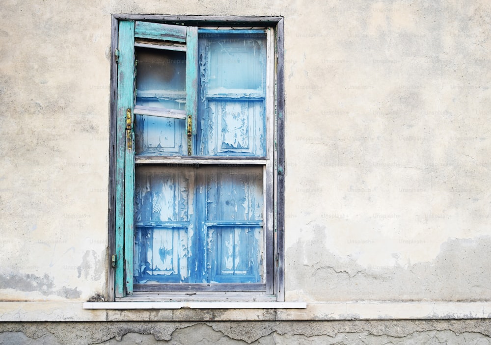 an old window with blue shutters on the outside of it