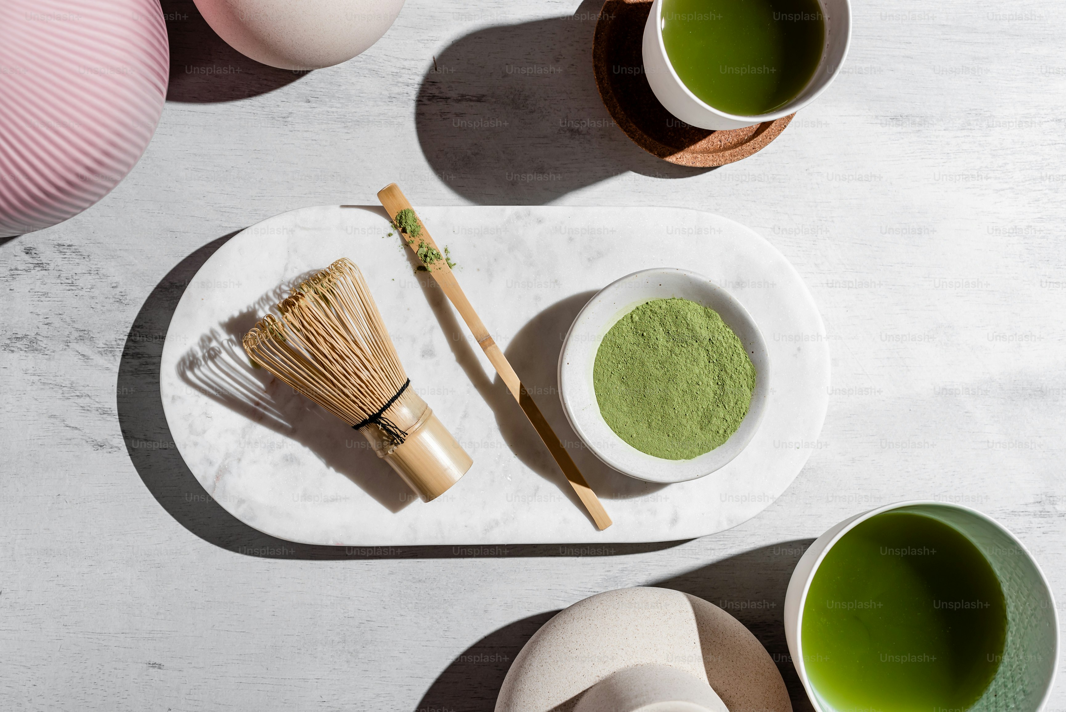 a table topped with bowls and cups filled with green tea