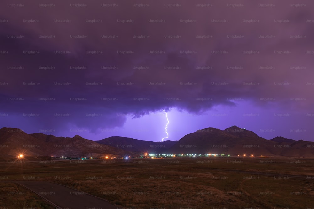 a lightning bolt is seen in the sky over a mountain range
