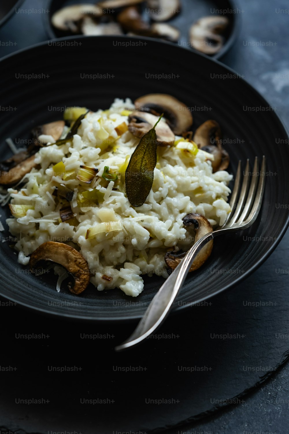 um prato preto coberto com arroz e cogumelos