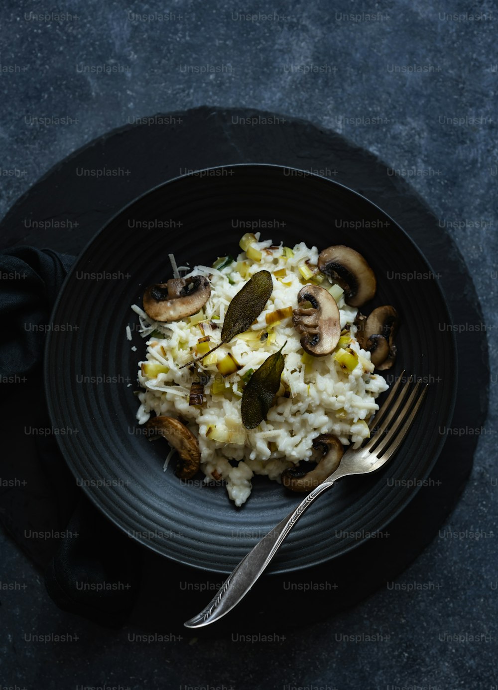 um prato preto coberto com arroz e cogumelos