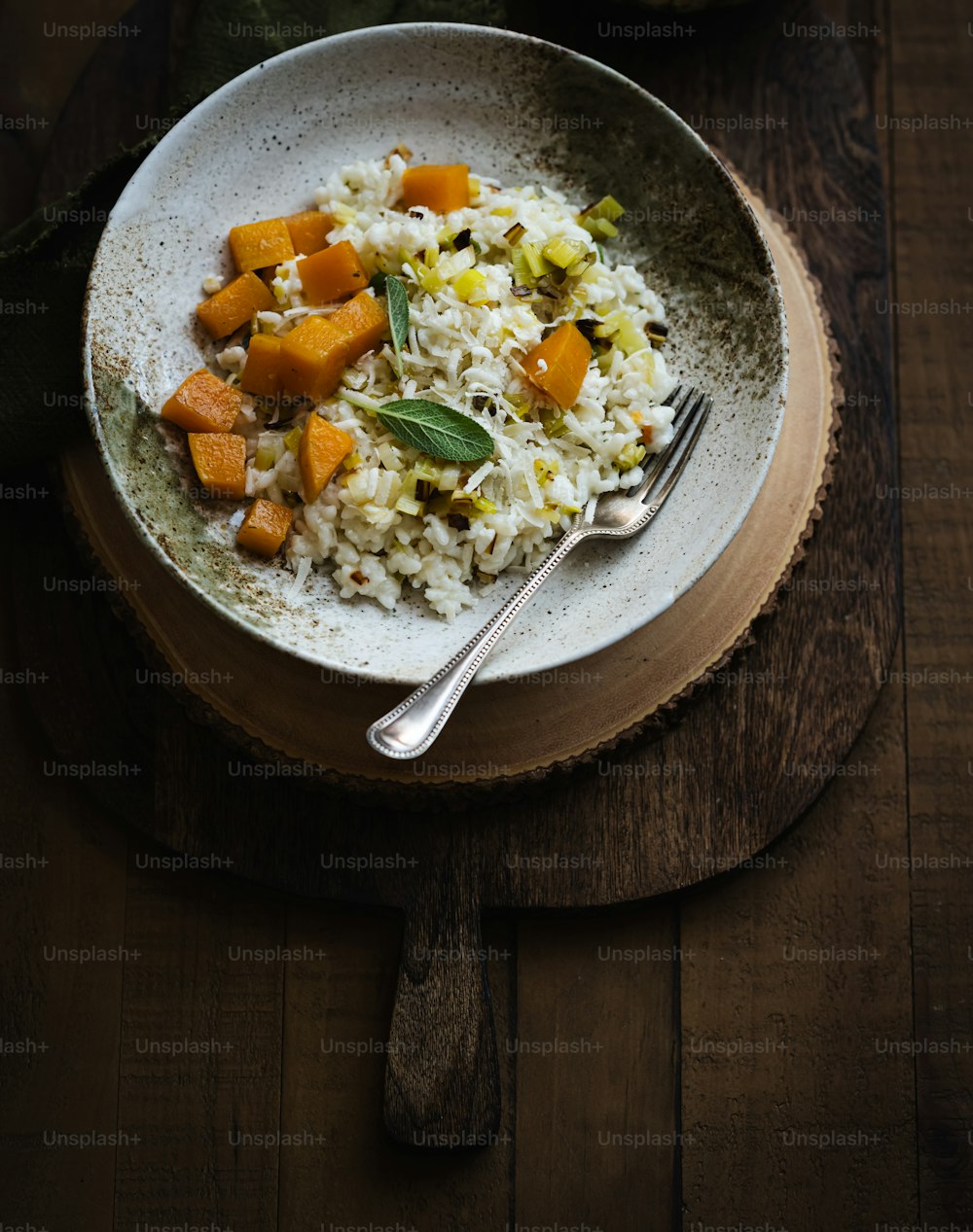 a bowl of rice and vegetables on a wooden table