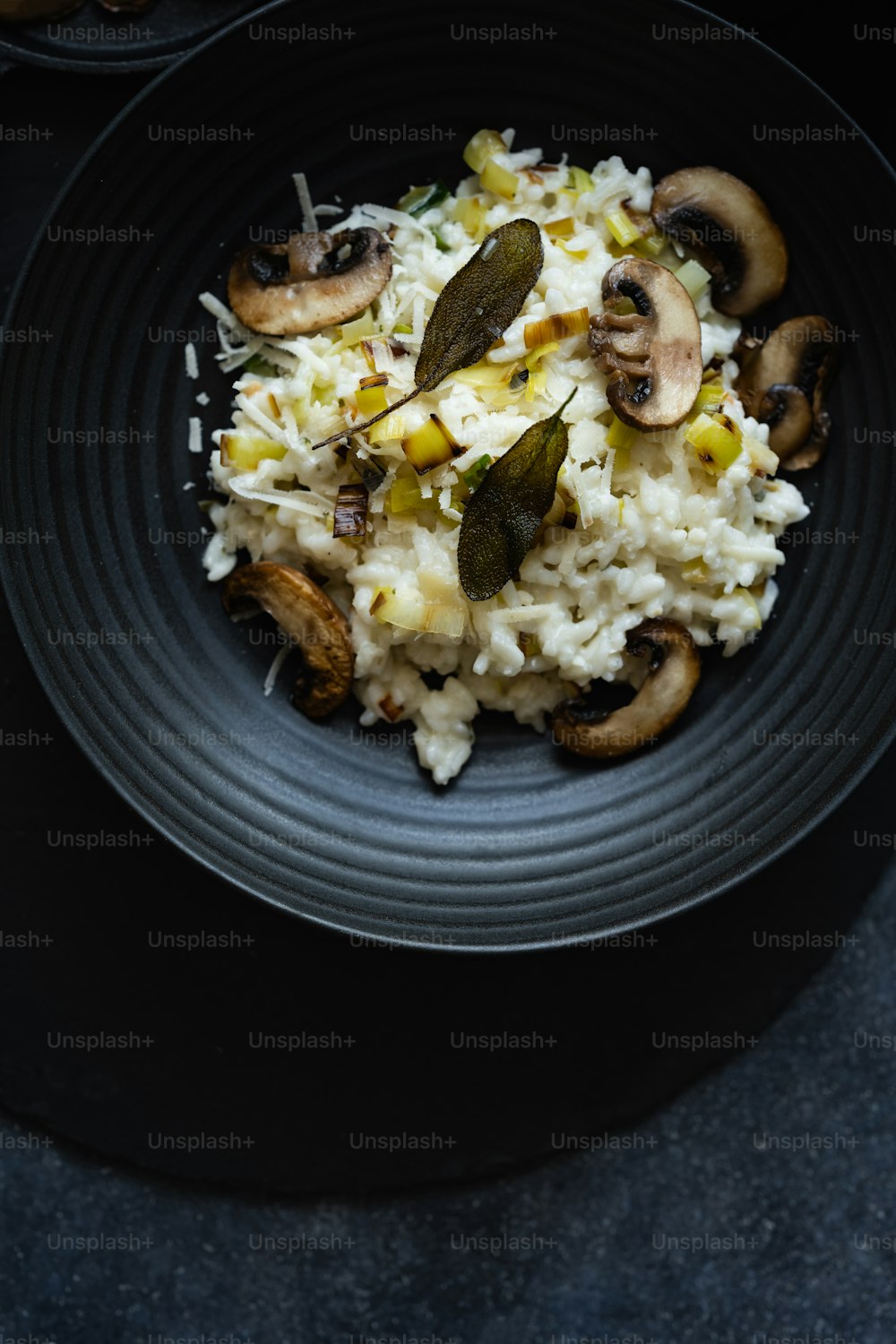 a black plate topped with rice and mushrooms
