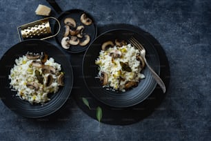 two black plates of food with mushrooms and rice