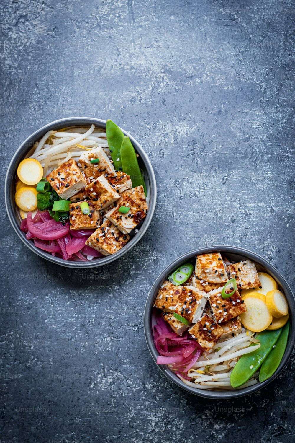 two bowls filled with food on top of a table