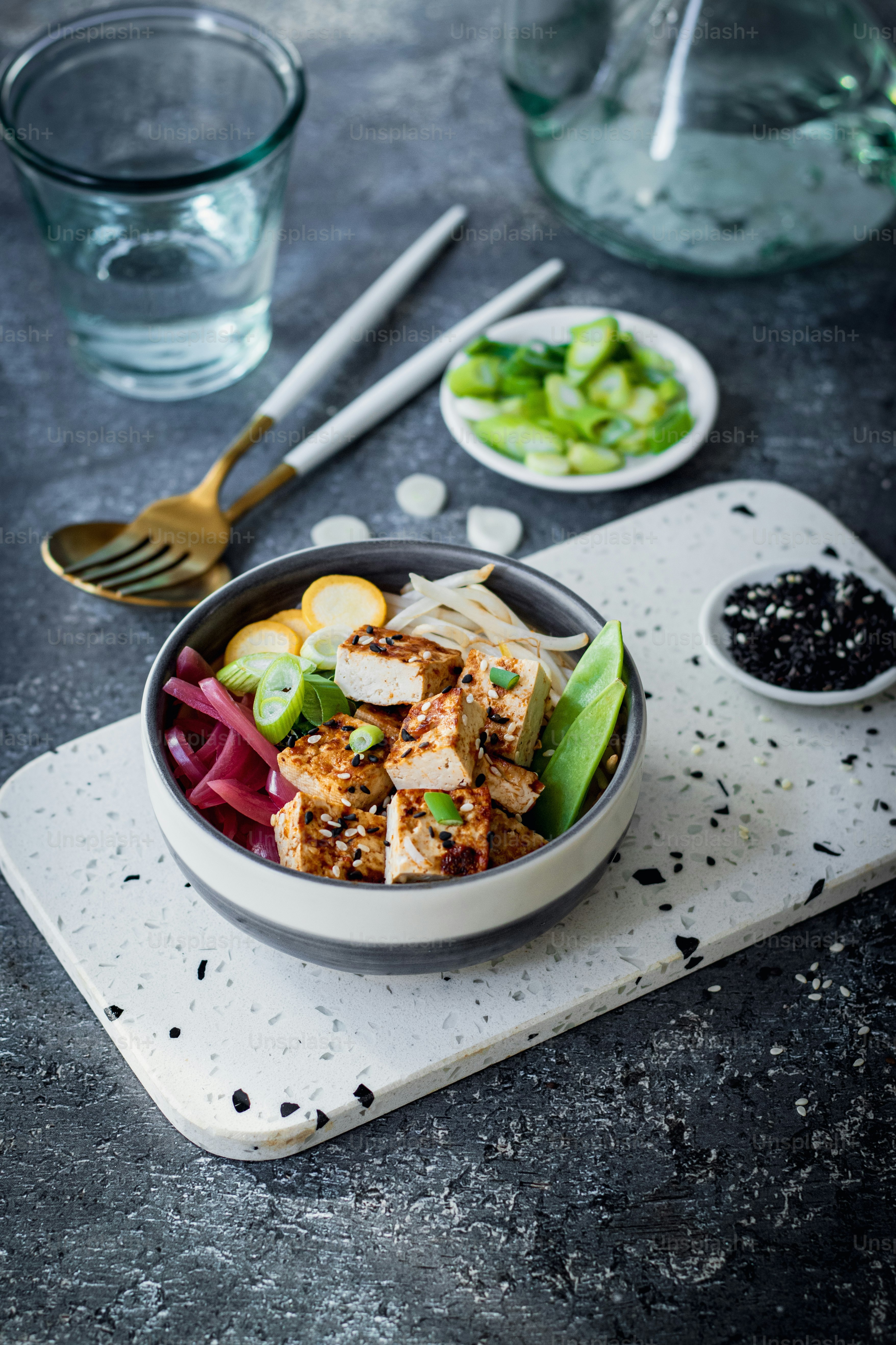 a bowl of food is sitting on a cutting board