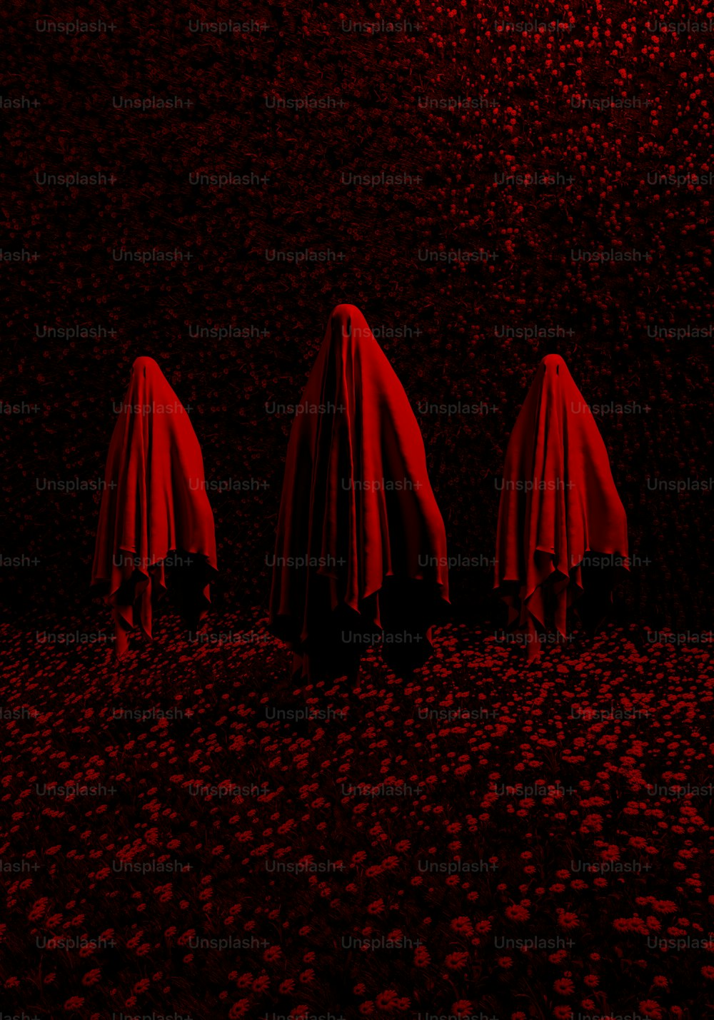 eine Gruppe von drei roten Regenschirmen, die in der Mitte eines Feldes sitzen