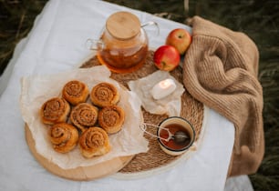 a plate of cinnamon buns next to a cup of tea