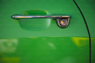 a close up of a door handle on a green car