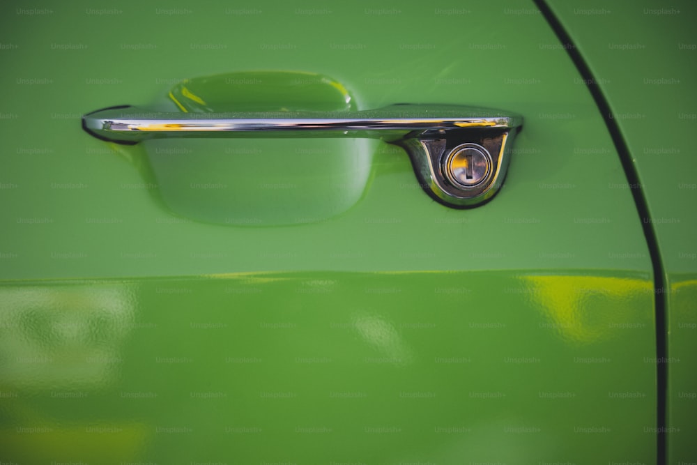 a close up of a door handle on a green car