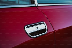 a close up of a door handle on a red car