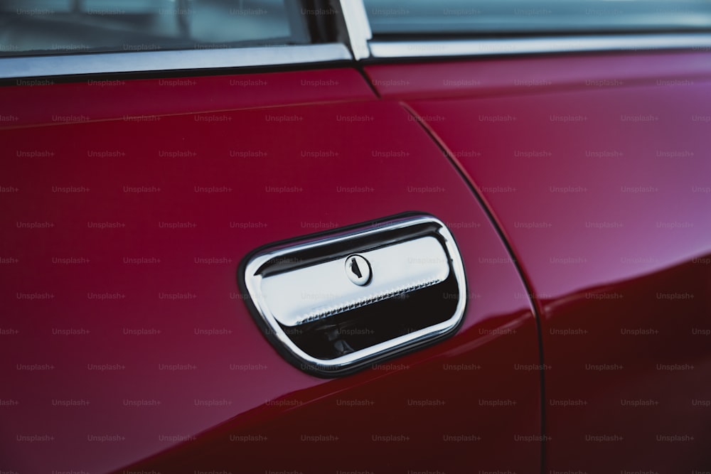 A close up of a door handle on a red car photo – Car Image on Unsplash