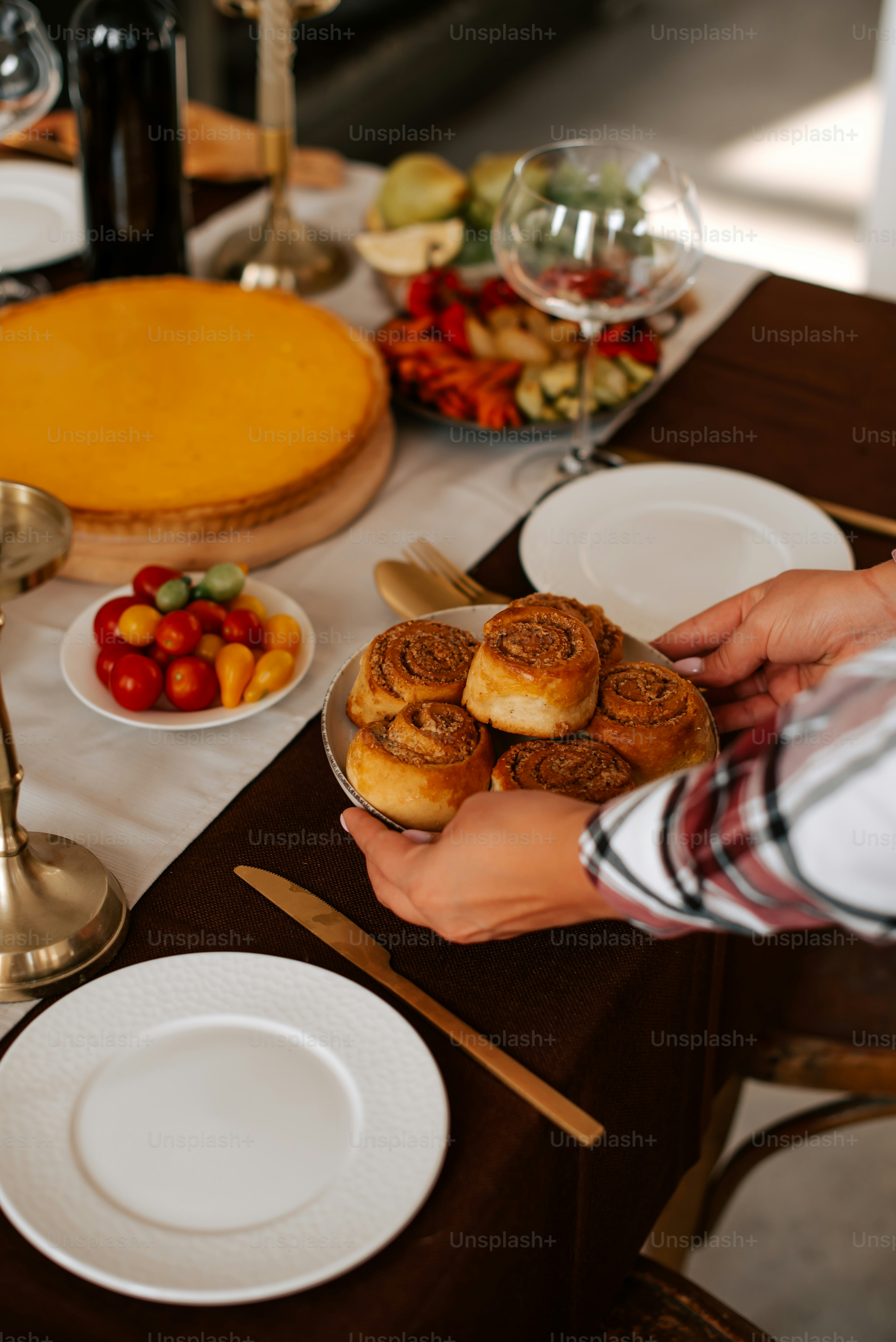 a person holding a plate of food on a table