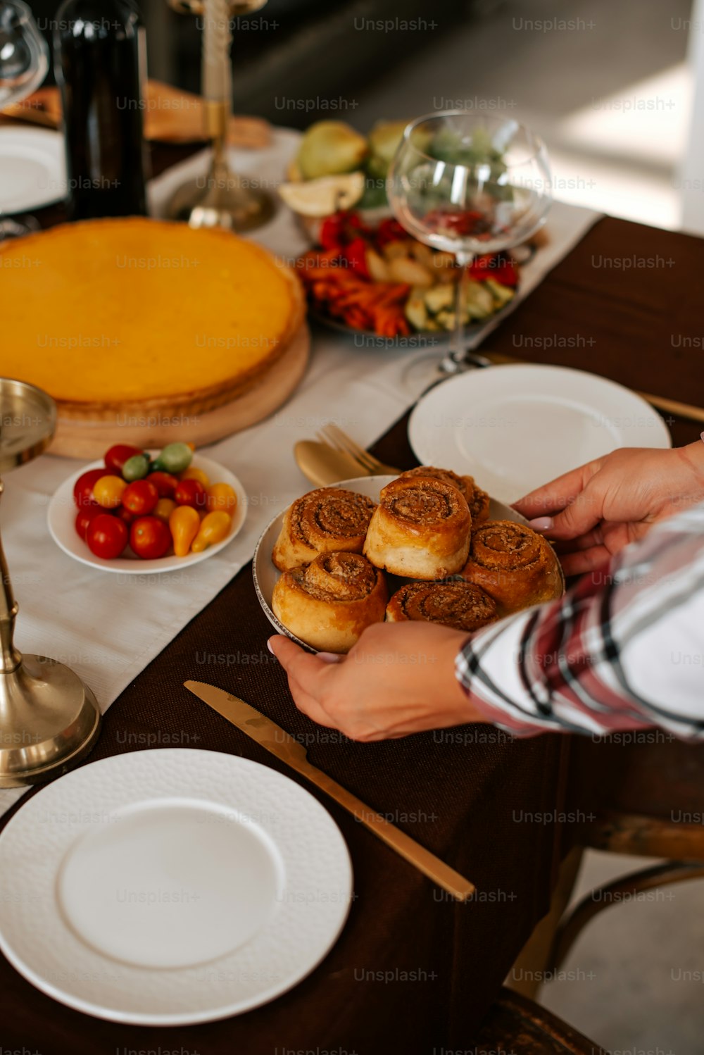 a person holding a plate of food on a table