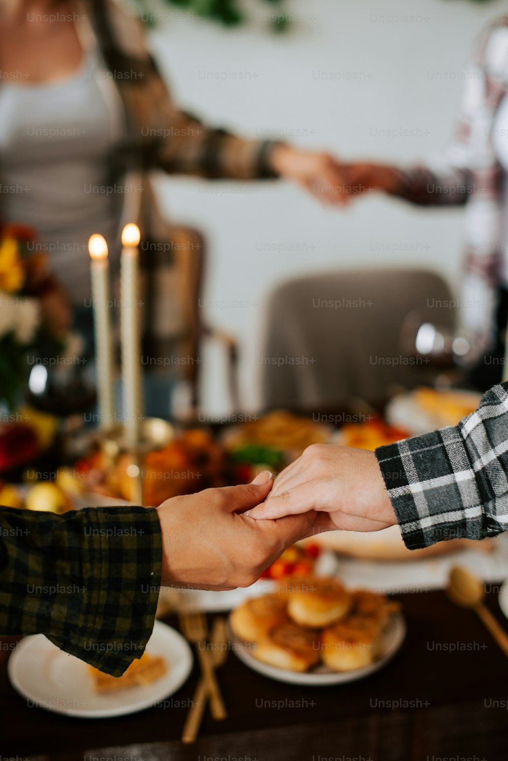 two people holding hands over a plate of food