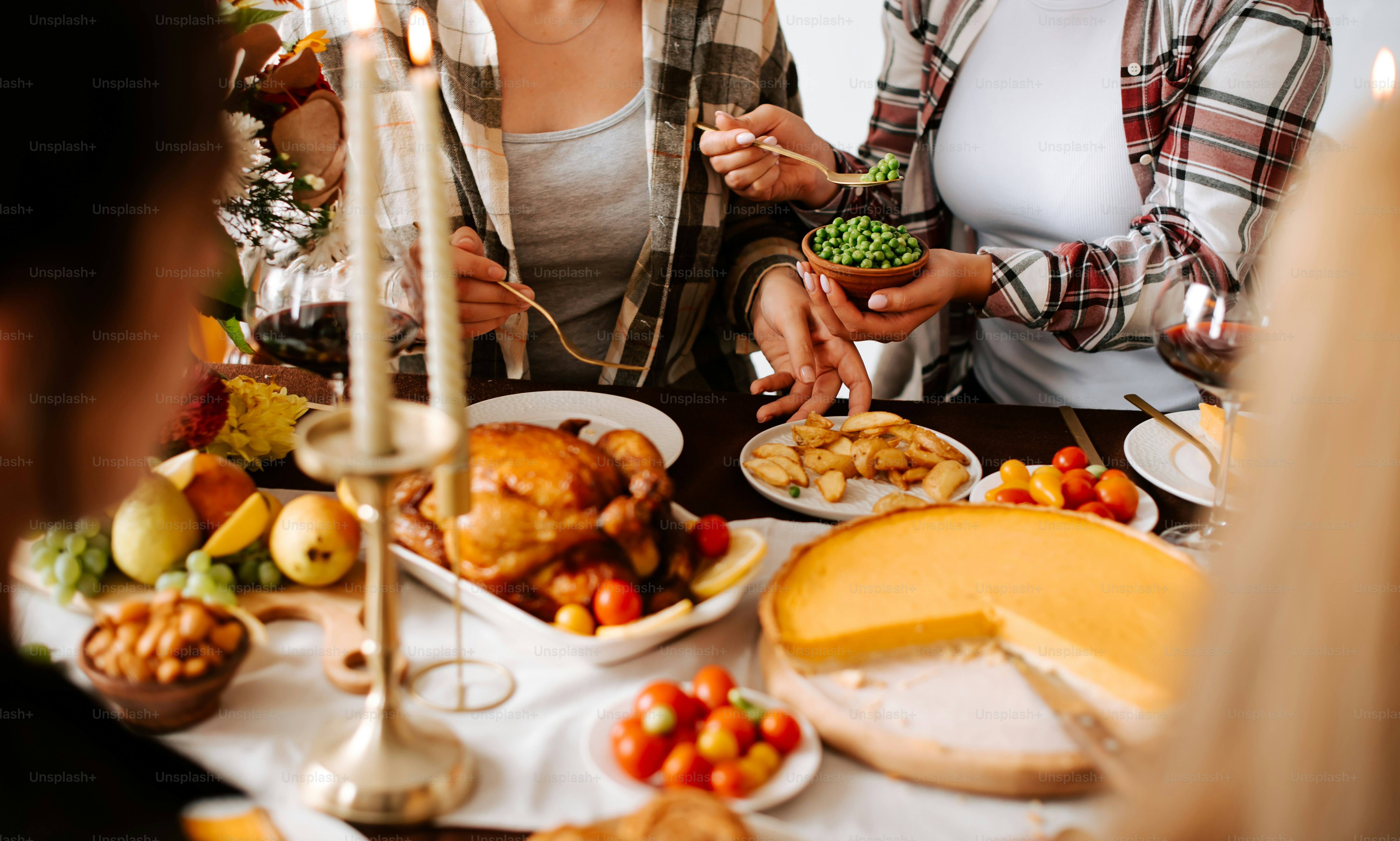 A group of people standing around a table filled with food photo ...