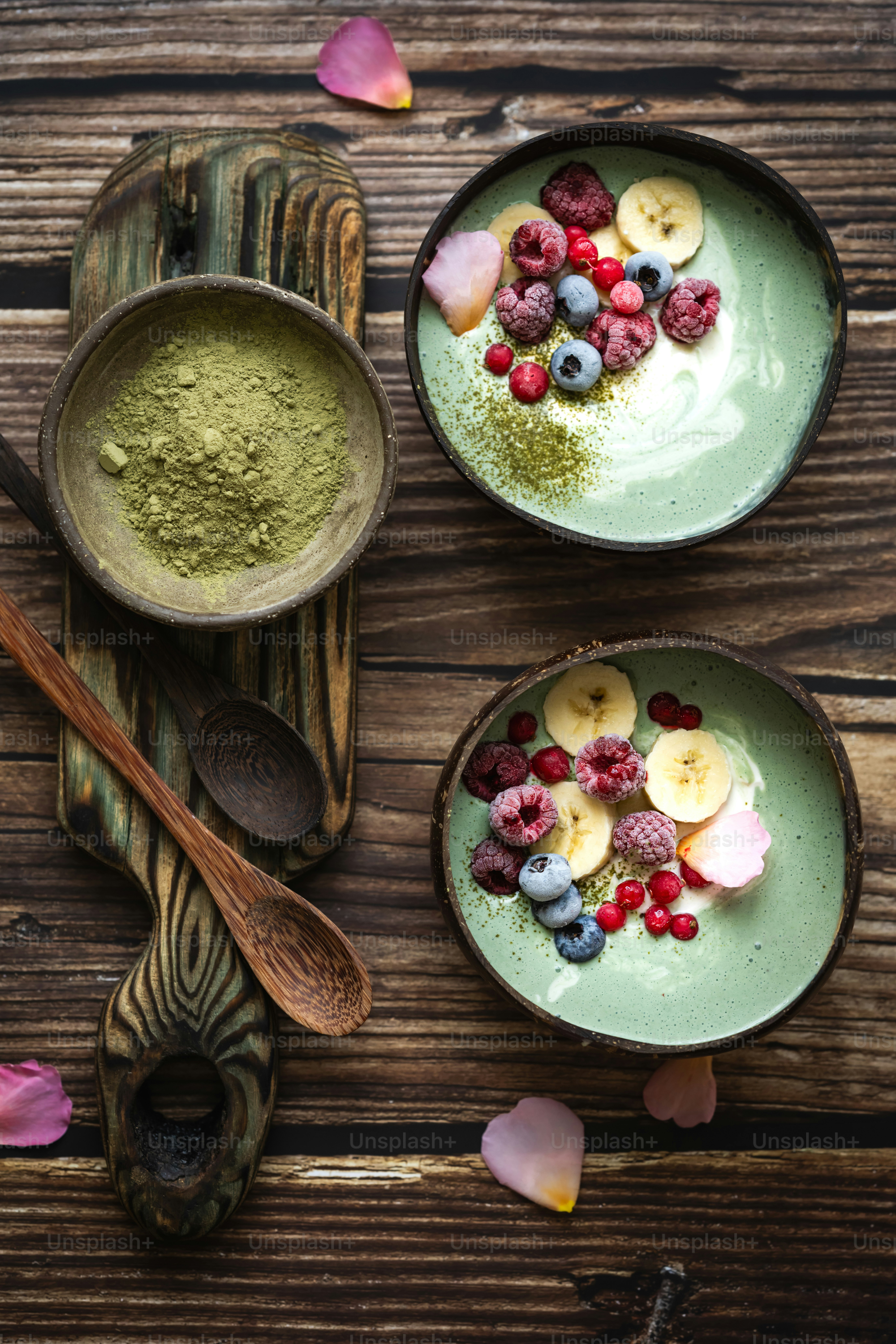 a couple of bowls filled with food on top of a wooden table