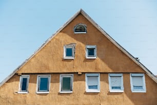 a house with three windows and a sky background